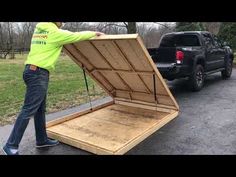 a man is unloading a large wooden box from the back of a pickup truck