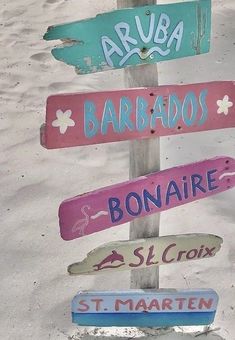 there are many different signs on the pole in the sand and one is for sale