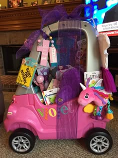 a pink toy car filled with lots of toys on top of a carpeted floor