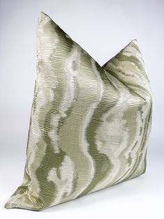 a large green and white pillow on a white background with an interesting design in the middle