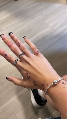 a woman's hand with stars and moon tattoos on it