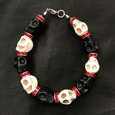 "If you're like me, you love skulls. So show your love with this skull bracelet! This bracelet features black and white howlite stone skulls and red stone crystal spacers, and is closed with a silver stainless steel lobster claw clasp. It comes in 3 sizes: Large - Fits wrists you to 7 1/2\" around Medium - Fits wrists up to 6 1/2\" around Small - Fits wrists up to 5 1/2\" around. If you need a different size, let me know and I will see what I can do. Make sure to check out my shop, PopBangBoom, Adjustable Red Beaded Bracelets For Halloween, Halloween Jewelry Diy, Diy Skulls, Red Gems, Skull Crafts, Gothic Jewellery, Seed Bead Crafts, Skull Beads, Red Jewel