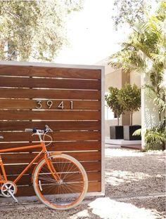 an orange bike is parked in front of a wooden wall with the word love written on it