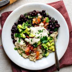 a white bowl filled with black beans and vegetables