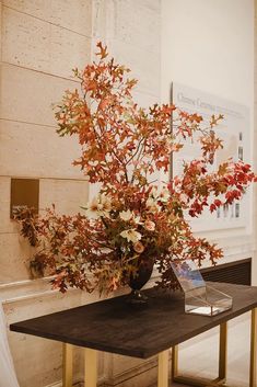 a vase filled with flowers sitting on top of a wooden table