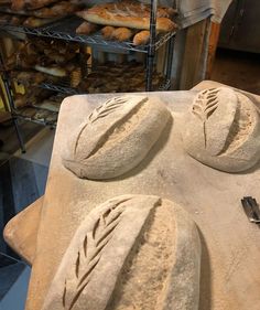 some breads are sitting on top of a tray in front of a rack with pastries