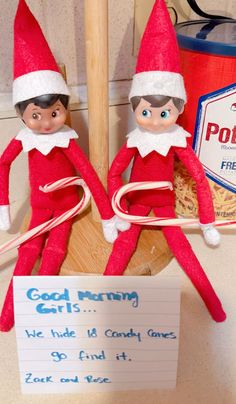 two elfs sitting next to each other on top of a wooden sleigh