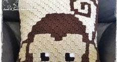 a crocheted pillow with a monkey on it's face is sitting in a chair