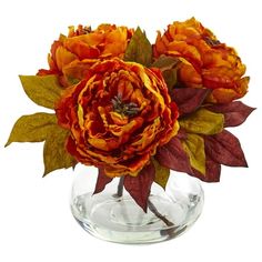 two orange flowers in a clear vase with leaves on the bottom and one red flower at the top