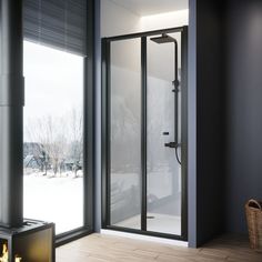 a bathroom with a glass shower door and wood flooring in front of a large window