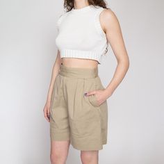 Vintage 80s high waisted khaki cotton shorts with pleating at the front. They have a zipper fly and two inner and outer buttons at the waist for closure. Great for a curvy fit! Measurements and Condition: Fits like: Labeled size 8, fits modern women's small to medium (see waist measurement to ensure fit) Fabric: Cotton Brand: Charter Club Condition: Very good, with light general wear Waist: 27" Hips: 46" - taken at the bottom of the zipper opening Rise: 14.25" Inseam: 7" Hem allowance: 2.5" Shown on a 5'8" model with measurements of 35"-26"-38", usually wears a size small to medium. See our FAQ for more info on sizing and condition ratings. High-waisted Khaki Shorts For Work, Fitted Khaki High-waisted Shorts, Fitted High-waisted Khaki Shorts, Chic High-waisted Khaki Shorts, Beige High-waist Cotton Shorts, Beige High Waist Cotton Shorts, Spring Khaki Shorts With Short Inseam, Khaki High-waist Relaxed Fit Shorts, Khaki High Waist Relaxed Fit Shorts