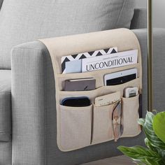 a couch with a magazine holder attached to the back of it and some other items inside