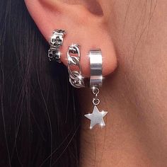 a close up of a person's ear with two rings and stars on it