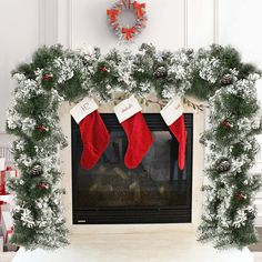 a fireplace decorated for christmas with stockings hanging from the mantel