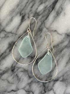 sea glass tear earrings on marble background