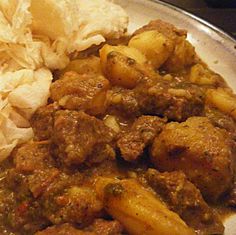 a silver plate topped with meat and potatoes