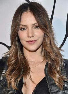 a close up of a person wearing a leather jacket and posing for the camera with long hair