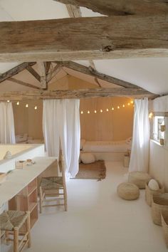 a room that has some chairs and lights on the ceiling in front of an open bathtub