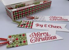 three christmas gift tags sitting on top of a table