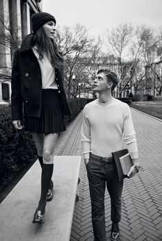 a man and woman walking down a sidewalk next to each other in black and white