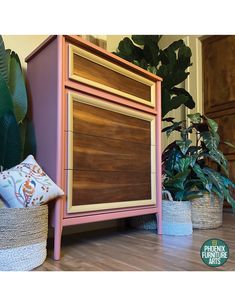 a wooden cabinet sitting next to a potted plant