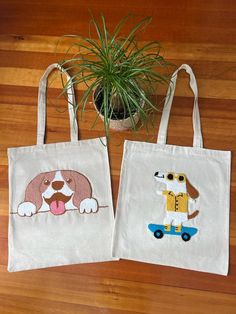 two bags with dogs on them sitting next to a potted plant