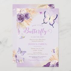 a purple and white butterfly baby shower with flowers on the bottom, in front of a marble background