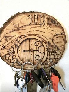 a wooden key holder with keys hanging from it's sides and an image of a hobbot door