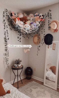 a bedroom with stuffed animals hanging from the ceiling and pillows on the wall above it