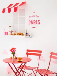 two red chairs sitting next to a pink table