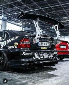 the back end of a black car parked in a garage