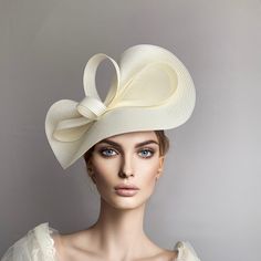 Elegant Cream Kentucky derby hat for woman. This ivory  fascinate hat is embellished with a big bow. It is a perfect hat for weddings, Royal Ascot horse races, Breeders cup, cocktails, derby... It is mounted on a headband. If you want, you can choose the side of the head were you like to wear the fascinator, just convo me. Any color of the fascinator can be changed to order.  * PROCESSING TIME: 5-7 business days. * DELIVERY TIME (DHL Express): 2-5 business days to all countries Elegant Kentucky Derby Hat With Bow, Elegant Bow Hat For Kentucky Derby, Elegant Cream Hat With Bow, Elegant Beige Curved Brim Fascinator, Elegant White Top Hat For Kentucky Derby, White Hat With Bow And Short Brim, Elegant White Headpiece For Kentucky Derby, Elegant Cream Hat With Short Brim, Elegant Summer Hats With Bow