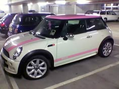 a white and pink mini car parked in a parking garage