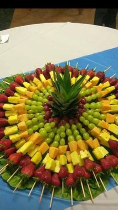 an arrangement of fruits arranged in the shape of a flower on a blue table cloth