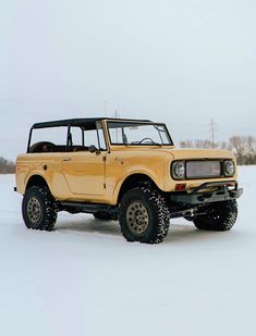 a yellow truck is parked in the snow