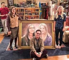 three people standing in front of a painting on the floor with two women and one man