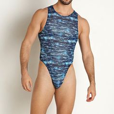 a man in a blue swimsuit standing against a white wall