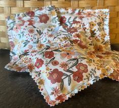 three pillows are sitting next to each other on a table in front of a basket