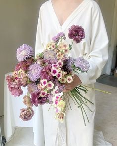 a woman holding a bouquet of flowers in her hands