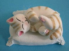 a stuffed cat laying on top of a pillow