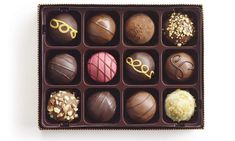 an assortment of chocolates in a box on a white background