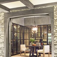 a dining room with stone walls and an arch leading into the wine cellar