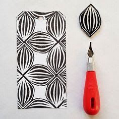 a pair of scissors and some black and white designs on a piece of paper next to a hole punch