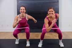 two women in pink workout clothes are doing squats