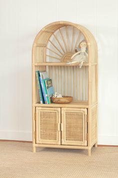 a wicker book shelf with books and a basket on top, against a white wall