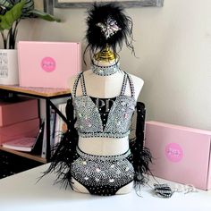 a mannequin is adorned with black feathers and beads