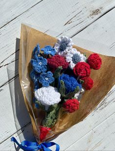 a bouquet of crocheted flowers sitting on top of a wooden table