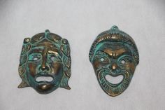 two green metal masks with faces on them