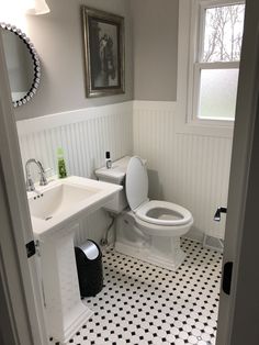 a white toilet sitting next to a sink in a bathroom