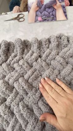 someone is crocheting a blanket with their hands